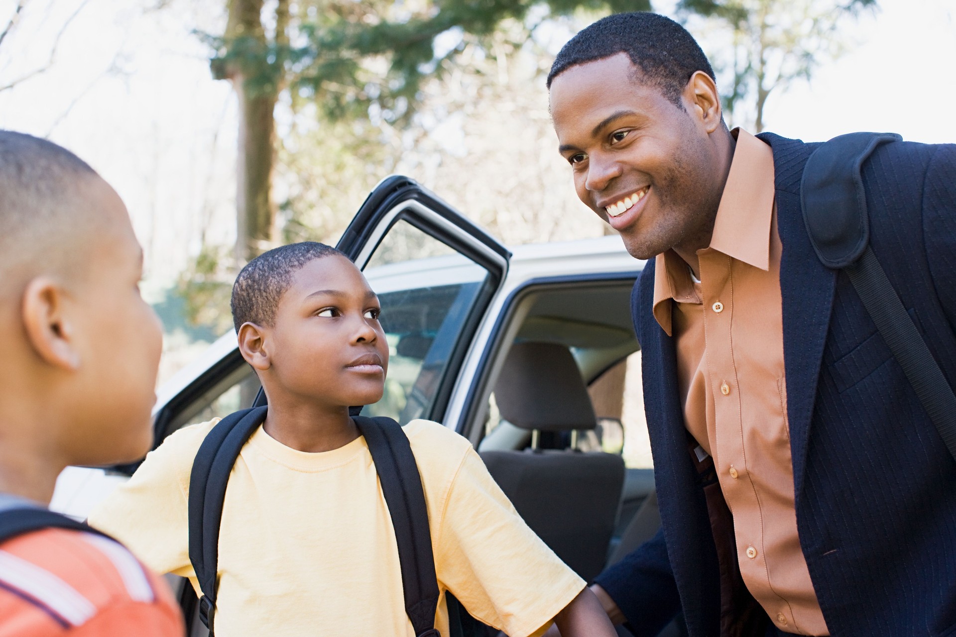 Father and sons by car